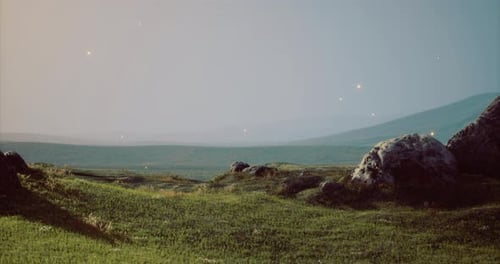 Endless Green Landscape with Gentle Hills and Distant Mountains at Dusk