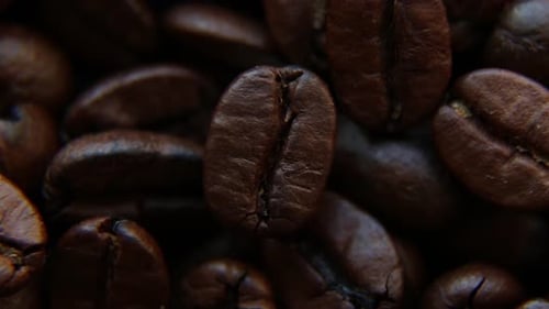 Eine Kaffeebohne rotiert vor dem Hintergrund der anderen Kaffeebohnen