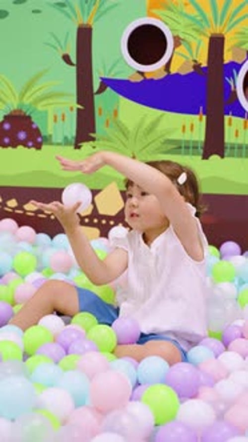 Girl Playing in a Colorful Ball Pit