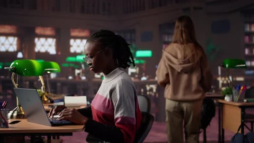 University Student Making Exam Preparations with a Friend at the Campus Library