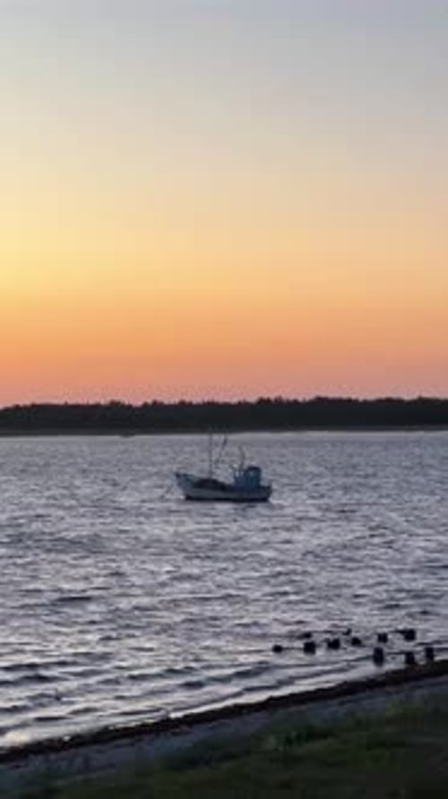 Small Old Boat Silhouette Near Shore at Sunset in Summer, Estonia Sea –