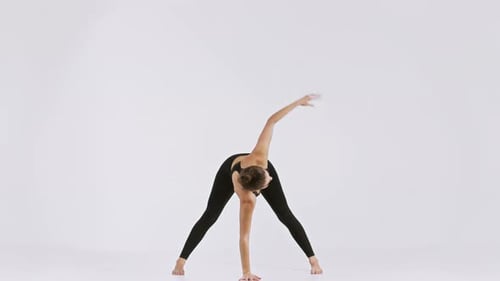 Young Woman Doing Stretching Exercises in Studio