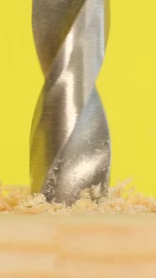 Drill bit drilling into piece of wood