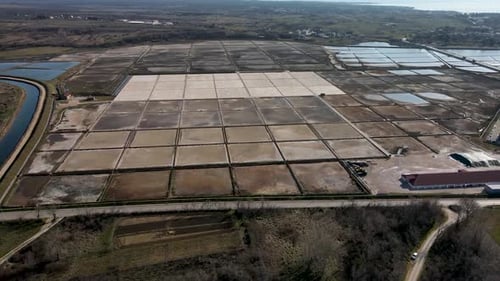Sideways drone flight close to a salt field in Croatia at daytime