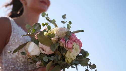 Woman Holds Wedding Bouquet of Flowers