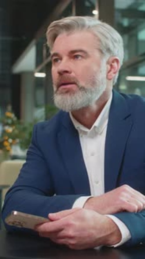 Mature Businessman Using Smartphone Becomes Shocked Sudden Lottery Results in Office Hotel Lobby