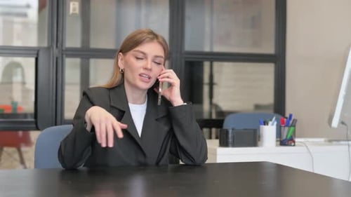 Young Businesswoman Talking on phone in Office