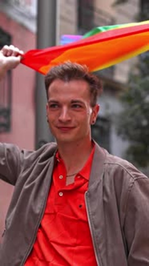 Proud Man Waving Rainbow Flag at Pride Parade
