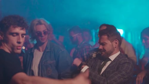 Young Adults Dancing in a Nightclub with Blue Lighting