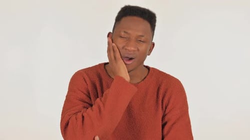 Porträt eines jungen afrikanischen Mannes mit Zahnschmerzen auf weißem Hintergrund