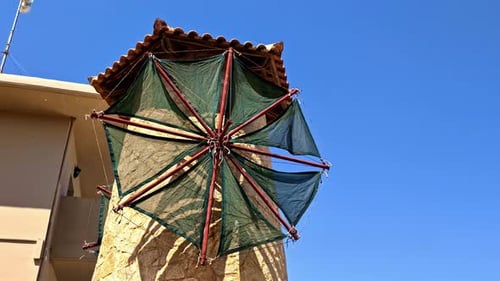 Landscape view of windmill on side of household home tower with tiled rooftop architecture exterior