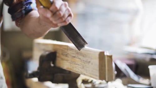 Man Crafting Wood Shaping with Chisel Tool