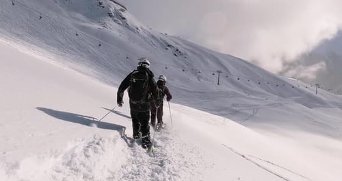 Freeride skiing with a professional ski mountain guide in deep snow off piste. Cinematic freeride sk