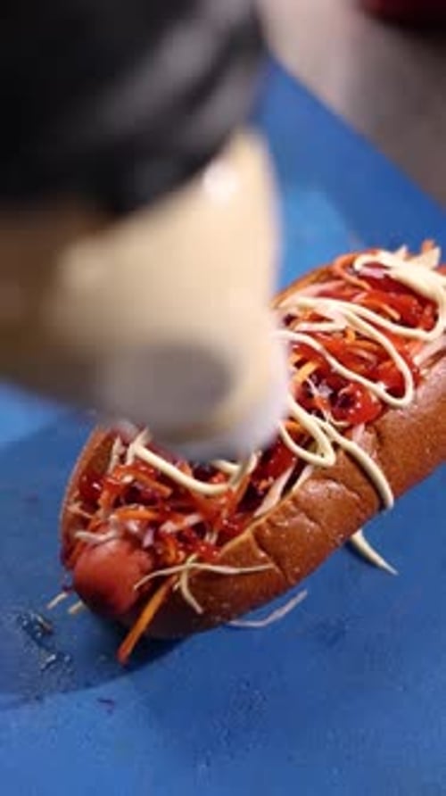 A chef prepares delicious hot dogs in a restaurant.