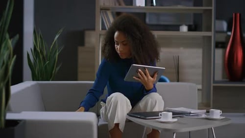 Woman Using Tablet and Answering Phone on Sofa
