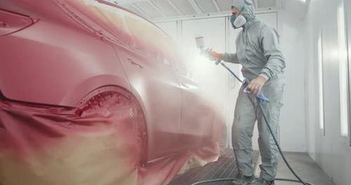 Professional Auto Worker Spray Painting Car in Body Shop