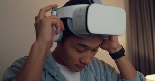 Young Adult Puts on Virtual Reality Headset Indoors