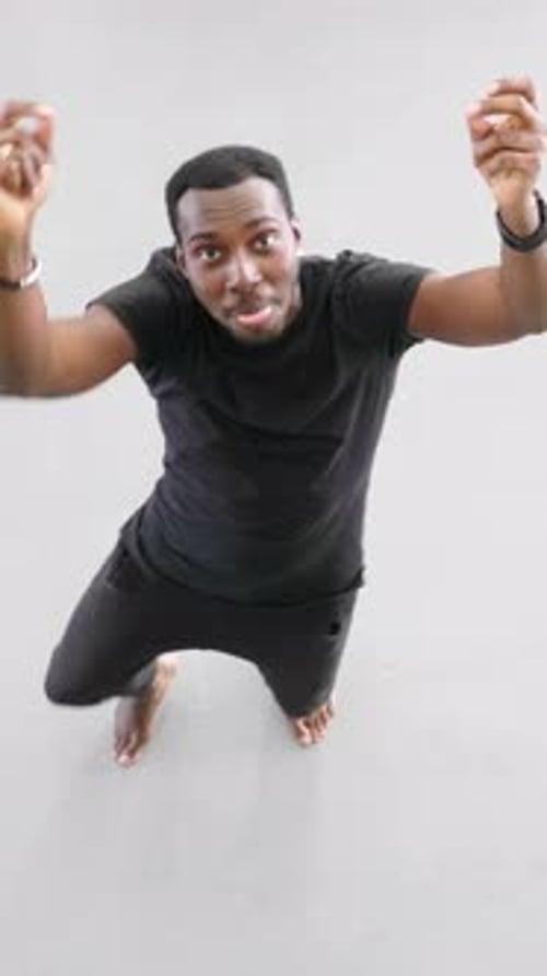 African American Man Performing Dynamic Dance Movements on a Smooth Floor in a Bright Studio