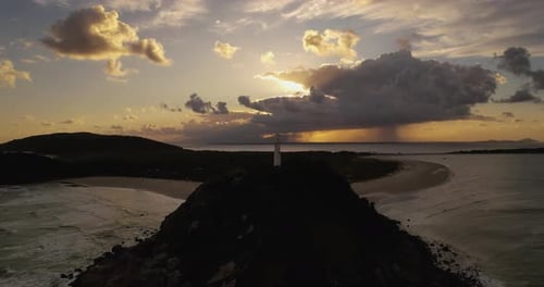 lighthouse on the beach at sunset
