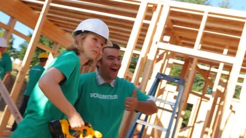 Volunteers building framing of new home construction site