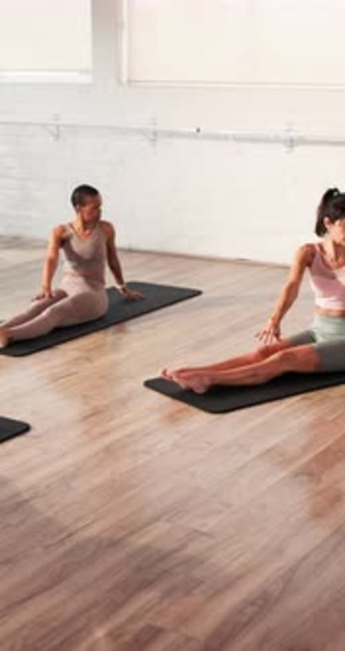 Women Exercising on Mats in Bright Fitness Studio