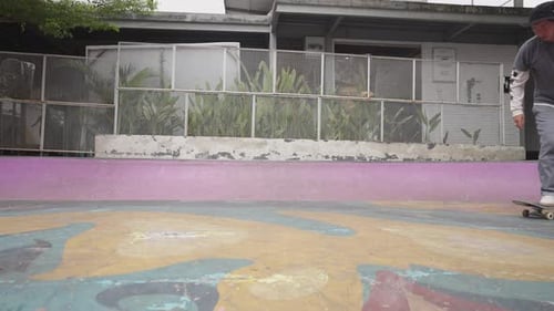 Un skateur fait du skateboard et saute sans se plier à 180 tours sur un skatepark local sous le soleil