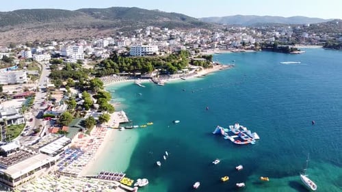 Ksamil, Albania - Reversing Aerial of Popular Holiday Destination with Hotels, Beachclub, Sunbeds, W