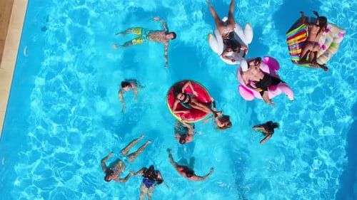 Aerial of Friends Having Party in Swimming Pool with Inflatable Flamingo Swan Mattress Happy Young