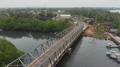 Aerial view of bridge over river surrounded by greenery, Indonesia.