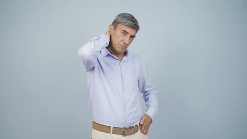 Gray-Haired Man Rubs Head, Neck, Shoulder in Discomfort