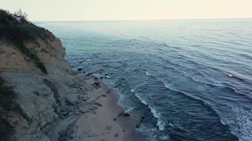 Ledge with Vegetation Over Beach in the Shadow Near the Black Sea Under a Blue Sky