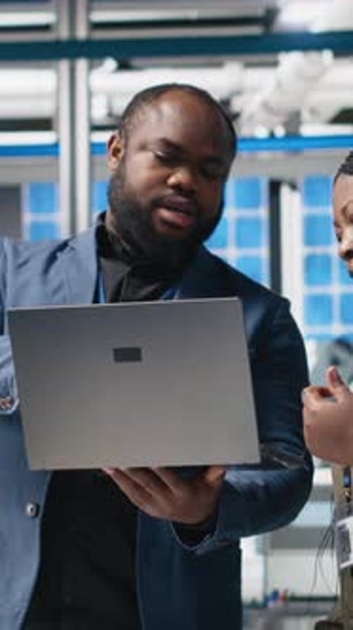 Vertical Video Black Factory Inspectors Engaging in a Briefing Over the Manufacturing Process