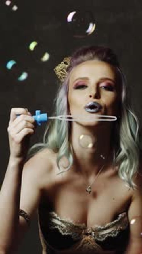 Woman with soap bubbles in studio.