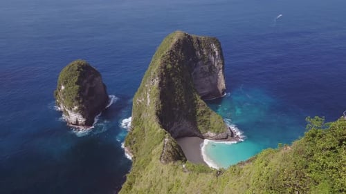 Aerial descent over a cliffs at Nusa Penida Kelingking Beach over cliffside