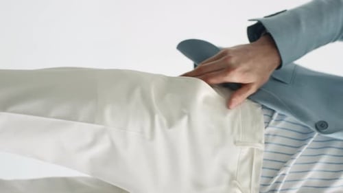 Man Reaches into White Pants Pocket
