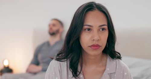 Sad Woman in Bedroom with Man in Background