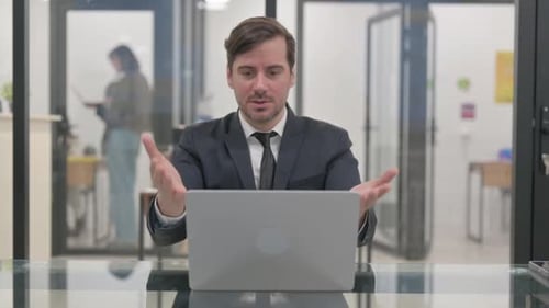 Frustrated Businessman Reacts to Laptop in Modern Office