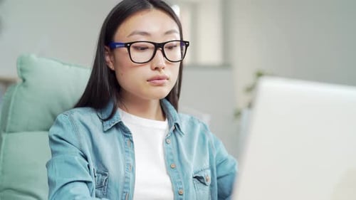 Woman Works on Laptop at Home in Daytime