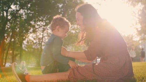 Brother and Older Sister Play in the Park in the Spring at Sunset Happy Family Slow Motion