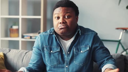 Portrait Young African American Man Look at Camera Face Sit on Sofa Home Close Up Slow Motion