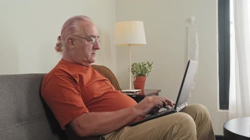 Senior Adult Typing on a Laptop Indoors