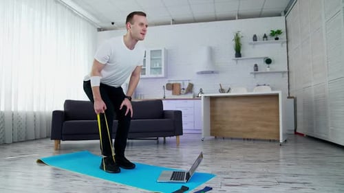 Man Working Out with Resistance Band at Home