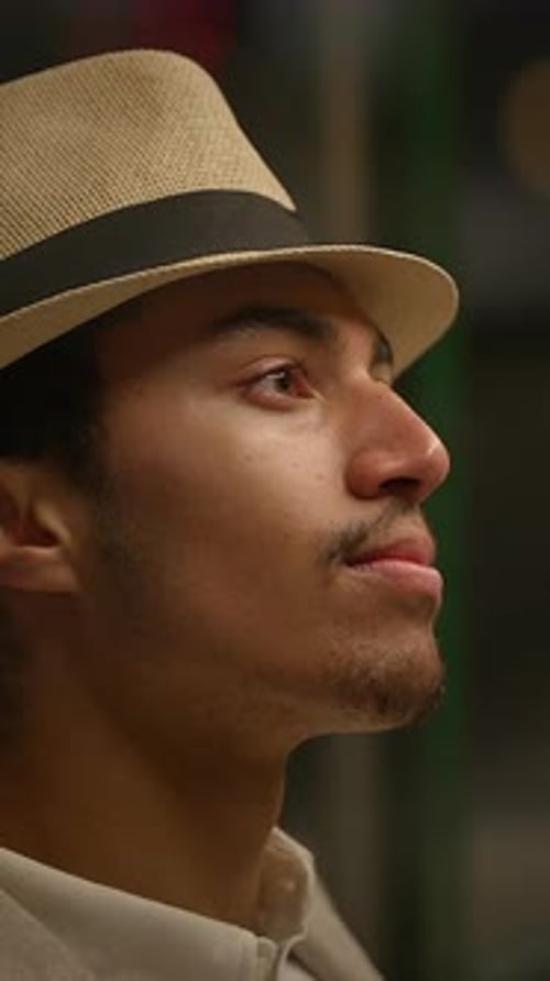 Portrait of Young Adult Male Taking Off Hat