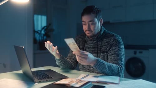 Dissatisfied Man Counting Euro Money at Home in a Dark Room During the Evening