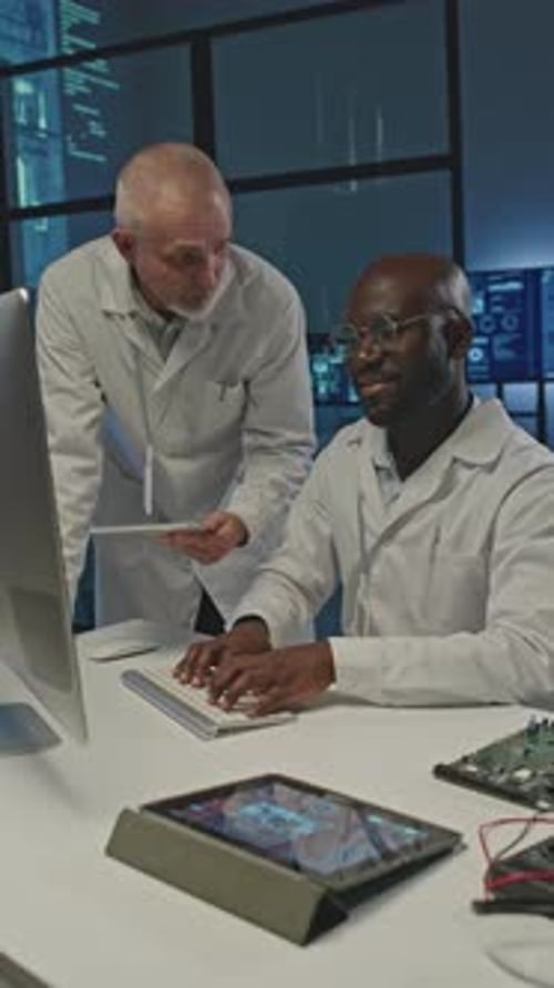 Zwei Elektronikingenieure arbeiten nachts am Computer