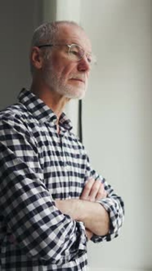 An Elderly Man is Sad at the Window in a Nursing Home Alone Old Age and Decay Illnesses of Adults