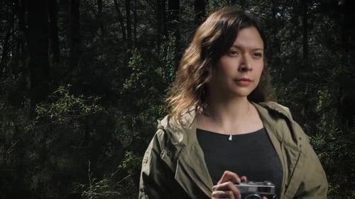 Slow-motion video captures a woman taking a photo in the woods, with each deliberate movement highli