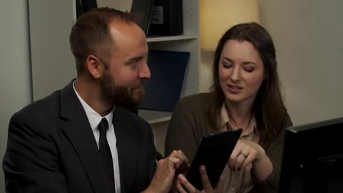 Team Discussing Business on Tablet in Office