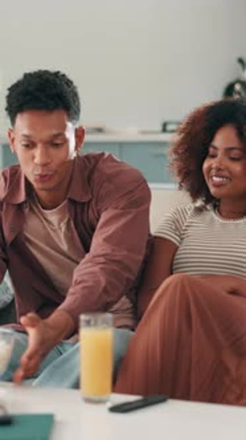 Loving Couple Watching TV and Eating Popcorn Together