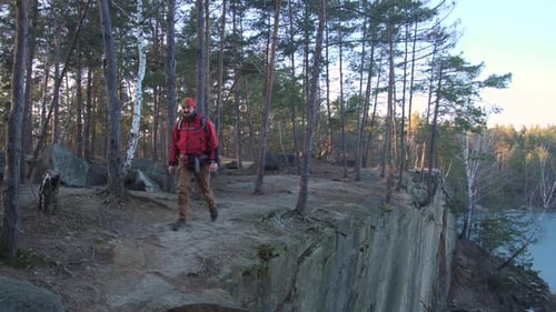 Alone Man Hiking in the Forest Along the Cliff